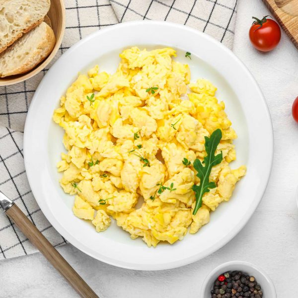 Composition with plate of tasty scrambled eggs and ingredients o